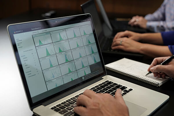Person reviewing lab data on a laptop using ASCENT 4